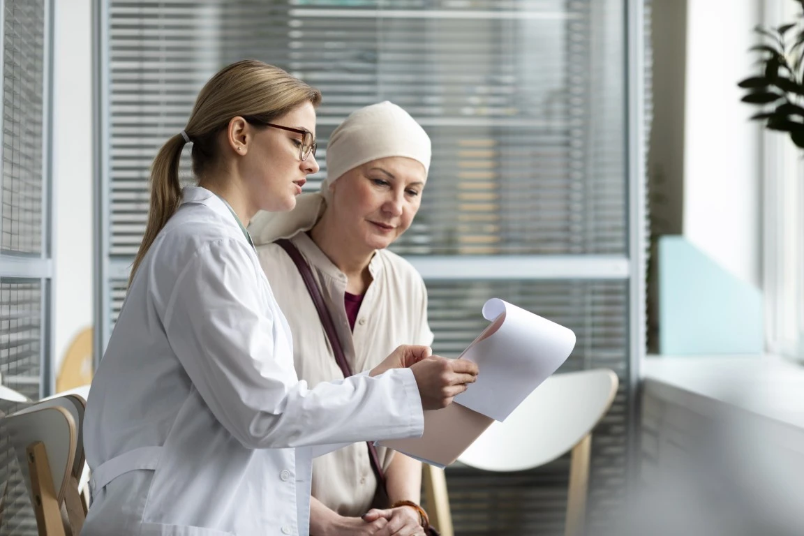 Médica conversando com uma mulher com câncer.